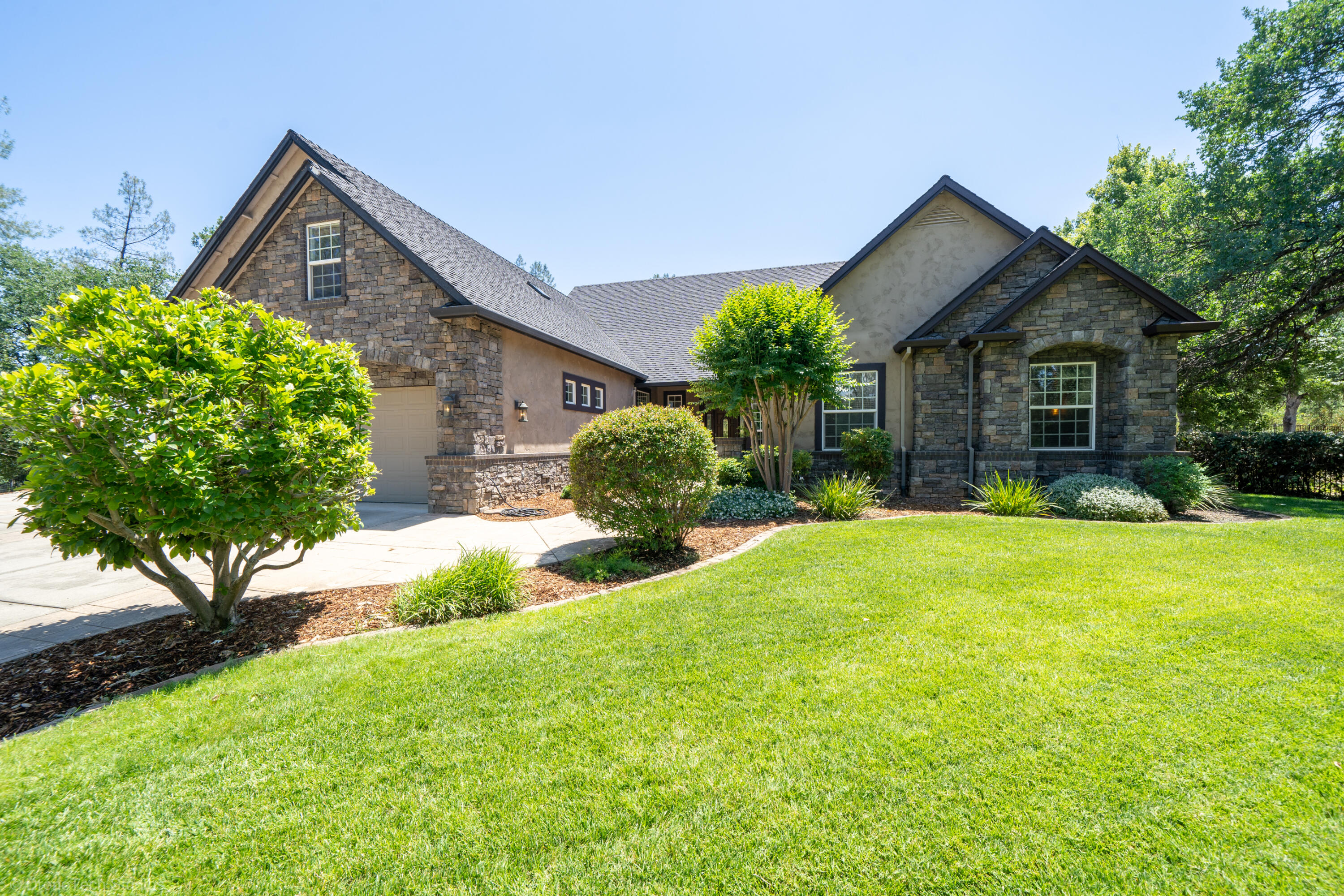 9109 Simmons Road Redding, CA 96001 - Photo 4 of 52 a front view of a house with a yard and garage