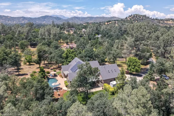 an aerial view of residential houses with outdoor space and trees