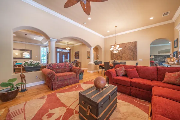 a living room with furniture a glass table and chairs
