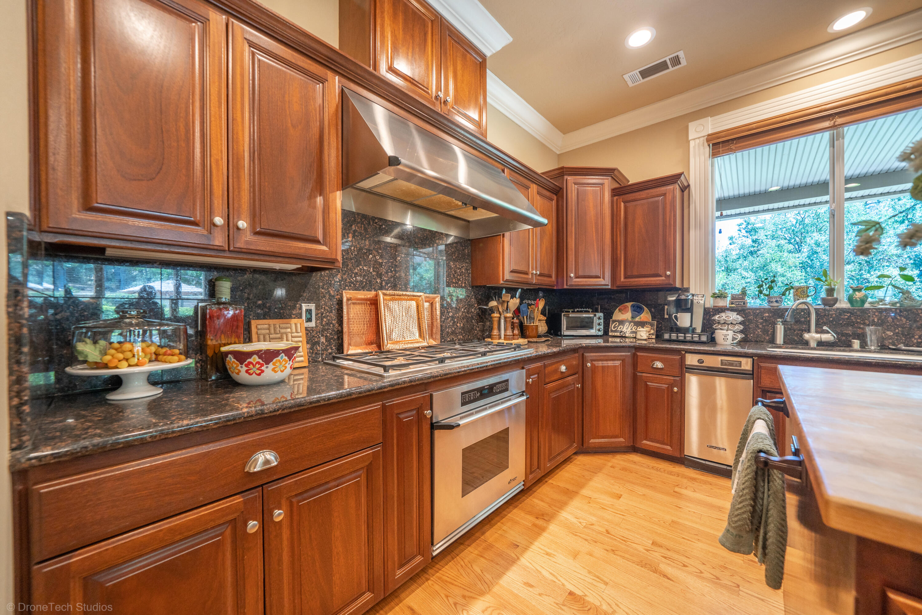 9109 Simmons Road Redding, CA 96001 - Photo 10 of 52 a kitchen with stainless steel appliances granite countertop a sink and wooden cabinets