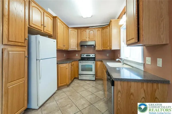 a white refrigerator freezer and a stove sitting inside of a kitchen