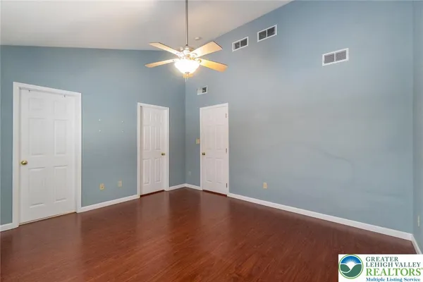 a view of an empty room with window and wooden floor