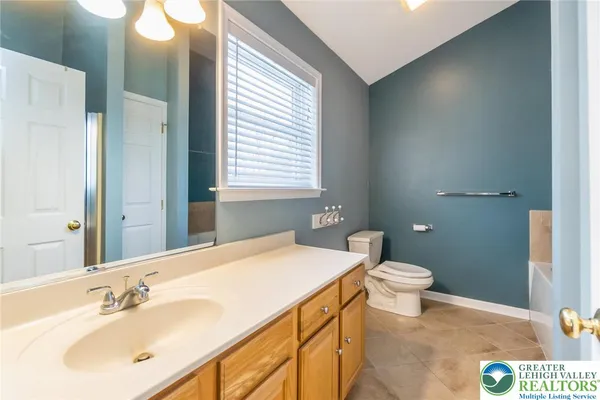 a bathroom with a tub a sink and a large mirror