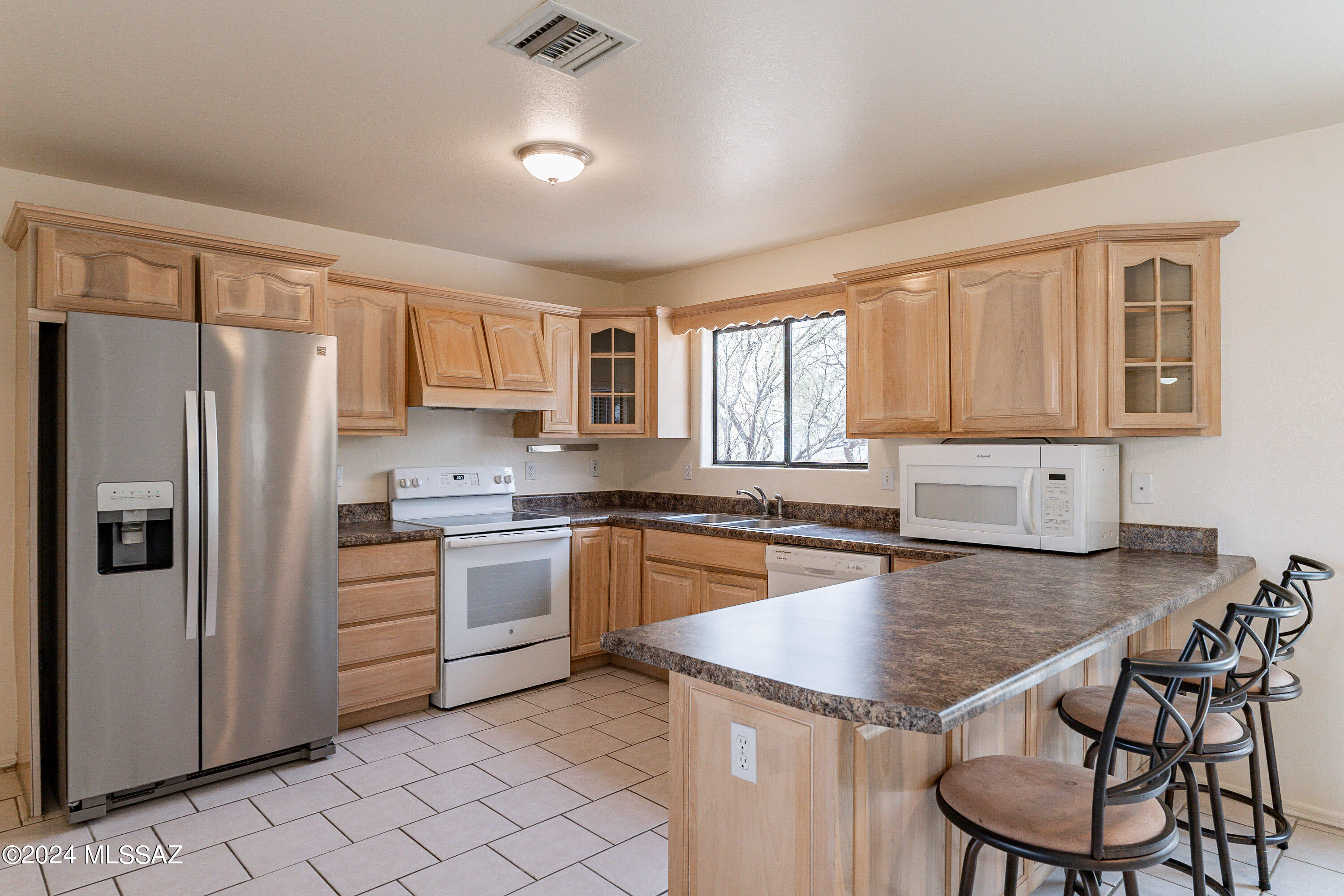 1380 Camino Faja Rio Rico, AZ 85648 - Photo 9 of 28 a kitchen with granite countertop stainless steel appliances a stove a sink a refrigerator a dining table and chairs