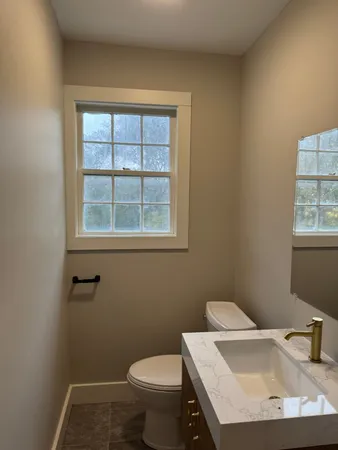 a bathroom with a sink a toilet and a window