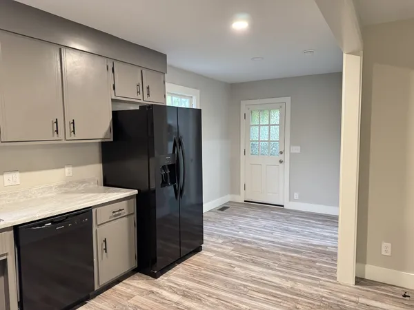 a kitchen with a refrigerator an oven and cabinets