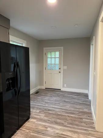 a view of empty room with wooden floor
