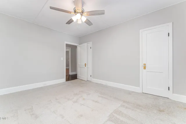 an empty room with chandelier fan