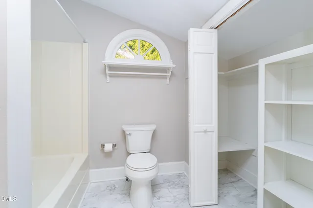 a kitchen with granite countertop white cabinets and a window