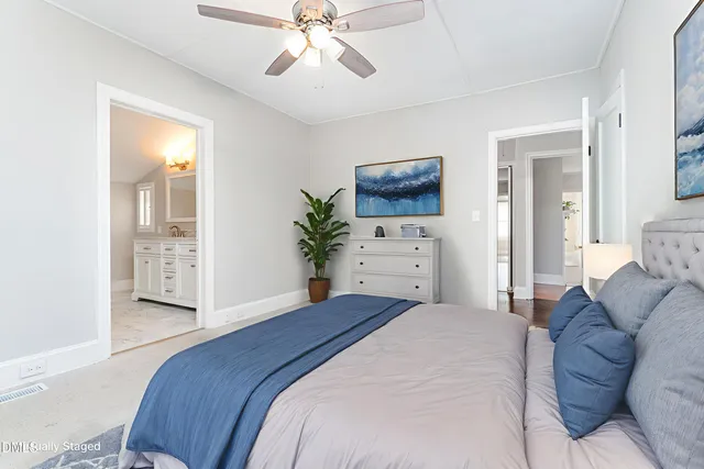 a spacious bedroom with a bed and a chandelier