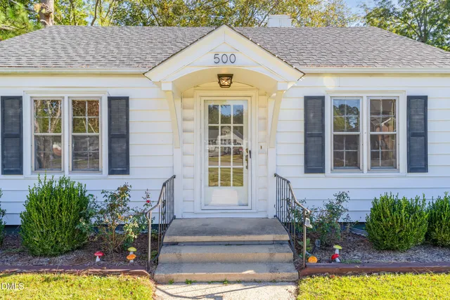 a front view of a house with potted plants