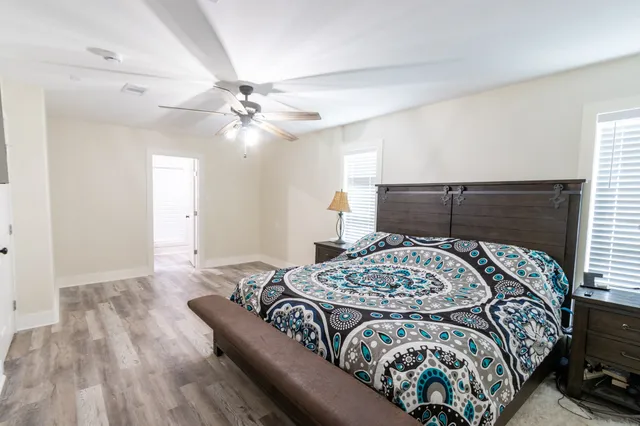 a bedroom with a bed and a dresser with rug