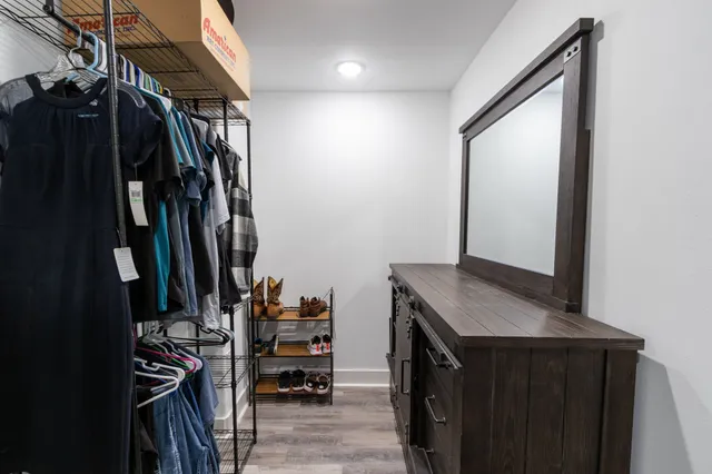 a view of walk in closet with clothes and shoes
