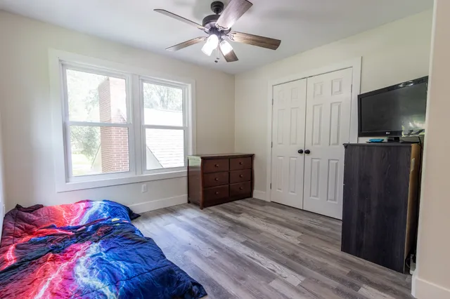 a living room with a bed furniture and a flat screen tv