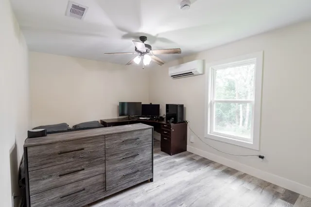 a view of workspace with wooden floor and ceiling fan