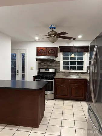 a kitchen with stainless steel appliances granite countertop a stove a sink and a refrigerator