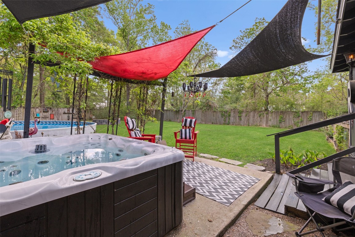 10960 McDowell Road Conroe, TX 77306 - Photo 20 of 25 Outdoor living space with stone patio and multiple seating areas.