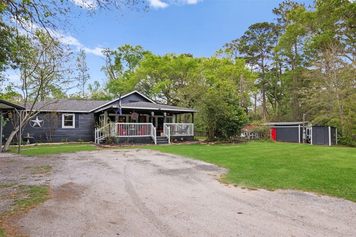 10960 McDowell Road Conroe, TX 77306 - Photo 2 of 25 Spacious driveway with ample parking and peaceful, tree-lined setting.