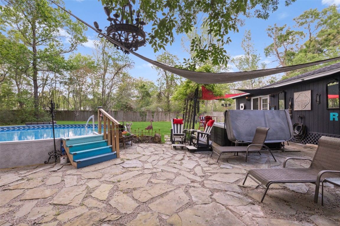 10960 McDowell Road Conroe, TX 77306 - Photo 21 of 25 Private outdoor oasis with multiple gathering spaces for hosting or unwinding.Enjoy the refreshing pool surrounded by lush greenery—perfect for summer days and the hot tub for cool evenings.