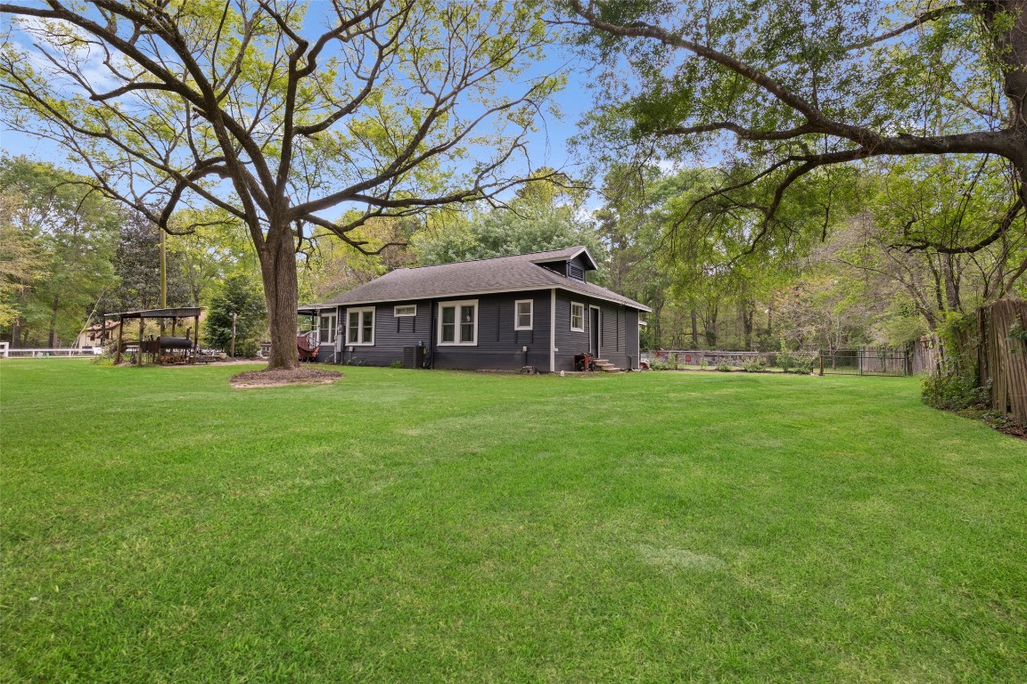 10960 McDowell Road Conroe, TX 77306 - Photo 23 of 25 Expansive backyard with mature trees and plenty of room to relax or entertain.