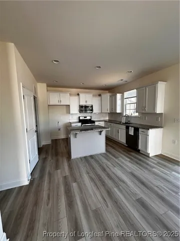 a kitchen with stainless steel appliances granite countertop a refrigerator a stove top oven a sink and dishwasher