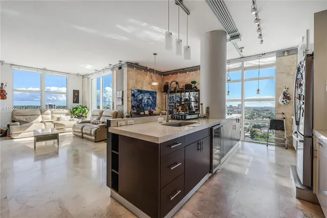 a large white kitchen with a large window and stainless steel appliances