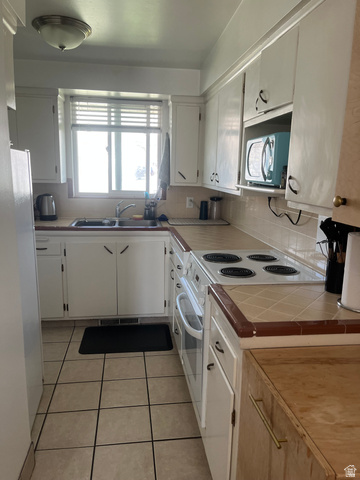 456 500 South Bountiful, UT 84010 - Photo 5 of 19 Kitchen with white appliances, light tile patterned floors, white cabinetry, tile counters, and decorative backsplash