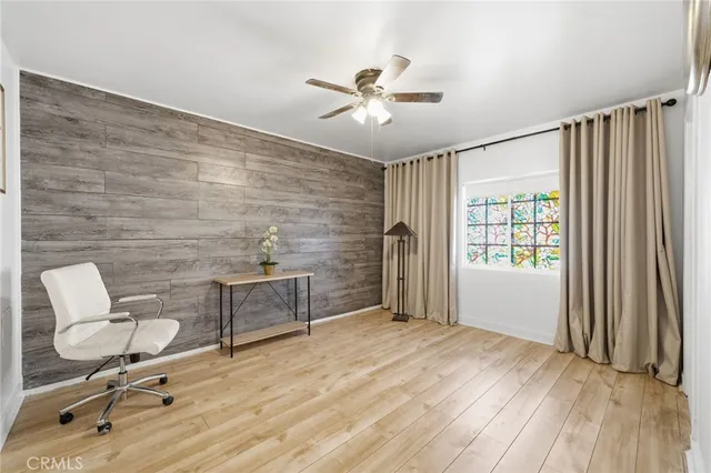 a view of a room with wooden floor and ceiling fan