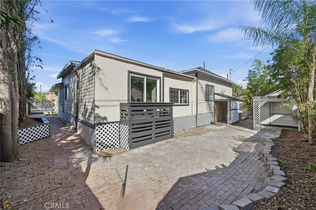 a view of a house with a small yard and wooden floor and fence