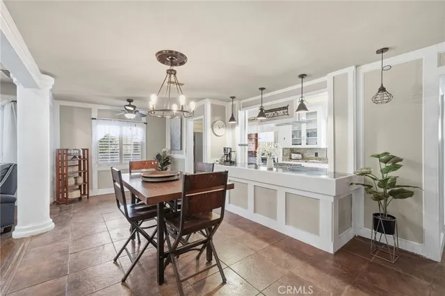 a kitchen with stainless steel appliances kitchen island granite countertop a dining table chairs and granite counter tops