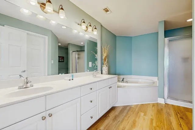 a spacious bathroom with a granite countertop sink mirror and a bathtub