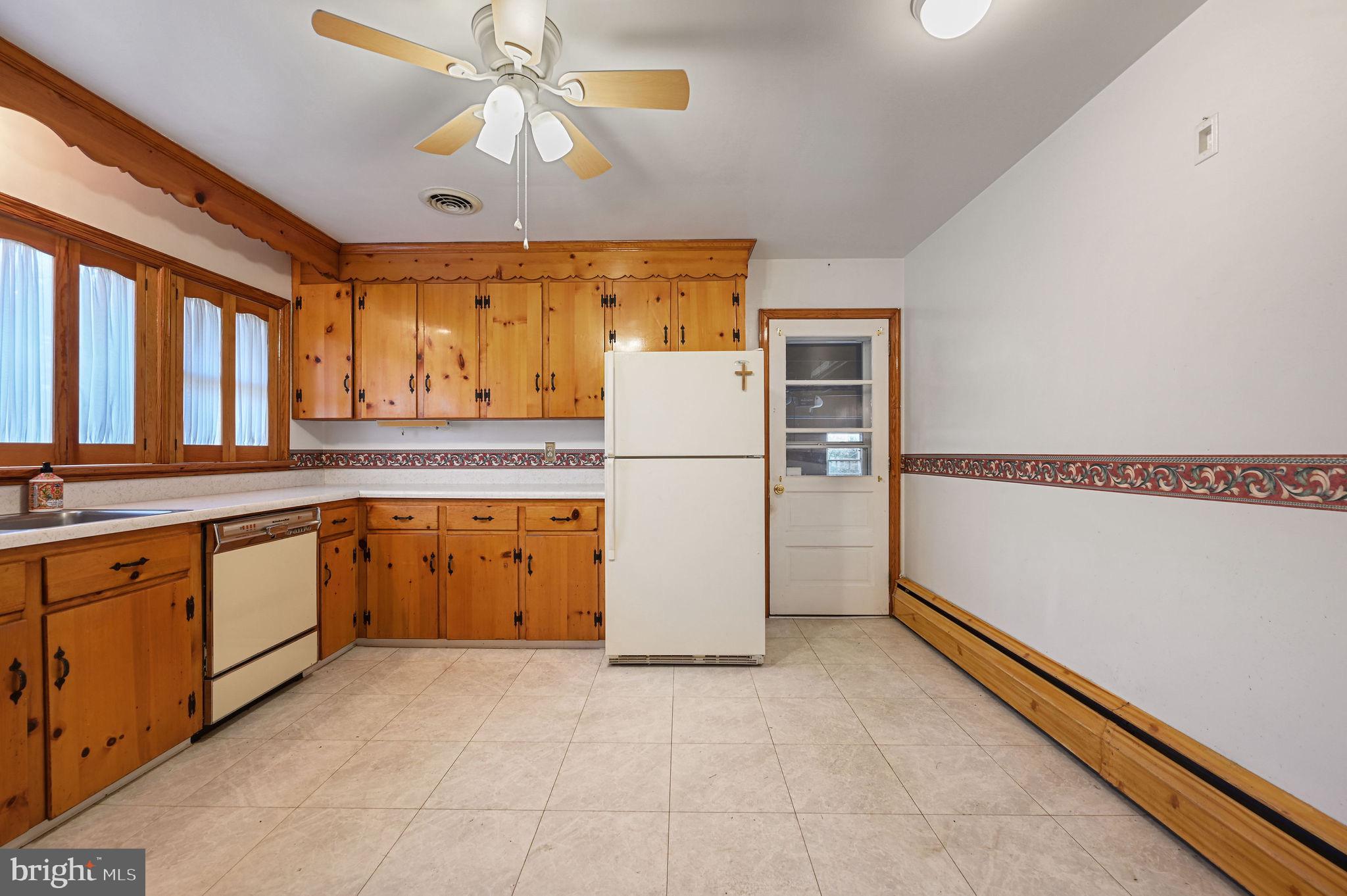55 Boyd Circle Dover, DE 19901 - Photo 6 of 24 a kitchen with a refrigerator a stove top oven and cabinets