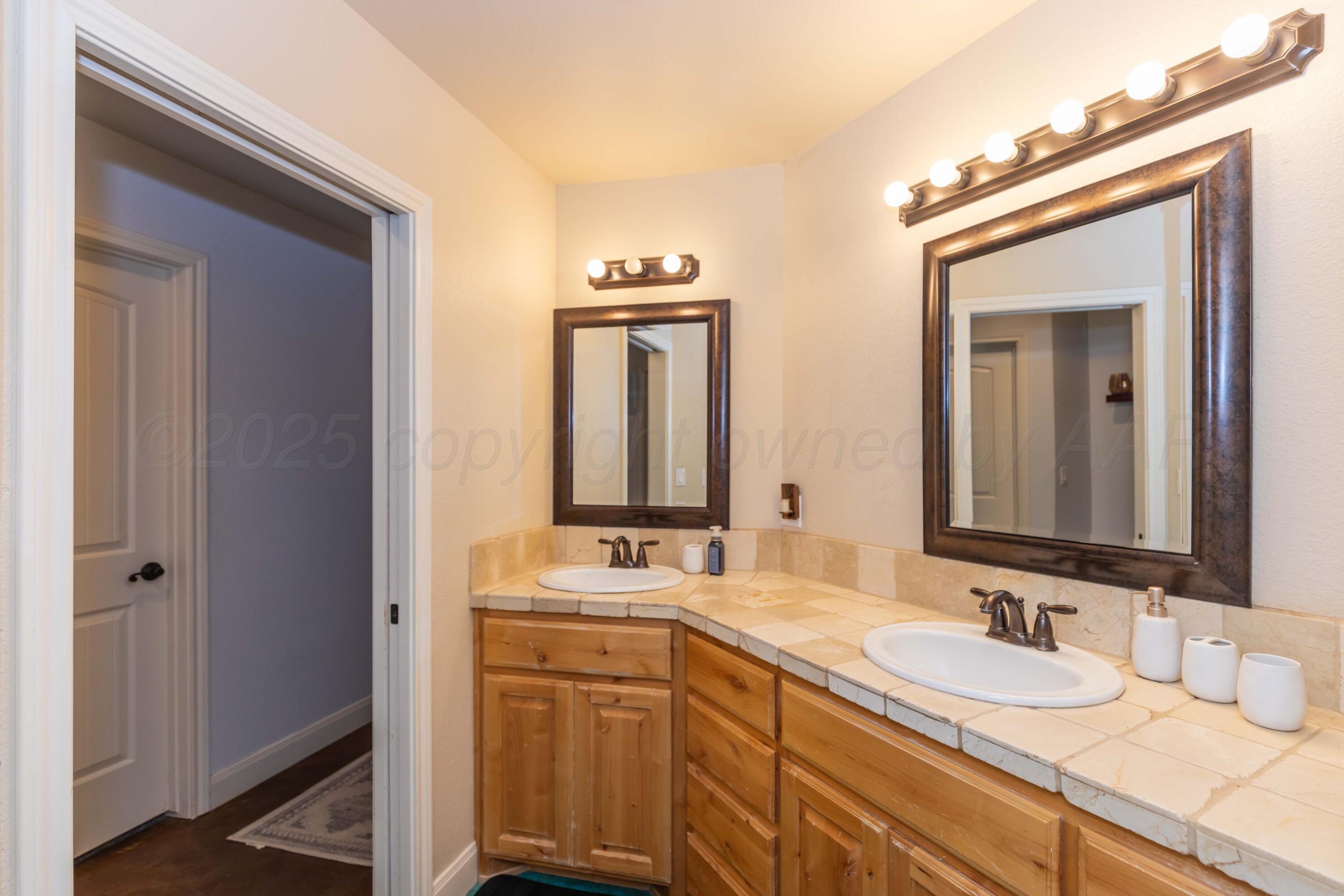 1301 Moon Ridge Lane Amarillo, TX 79124 - Photo 26 of 34 a bathroom with 2 sink and a mirror
