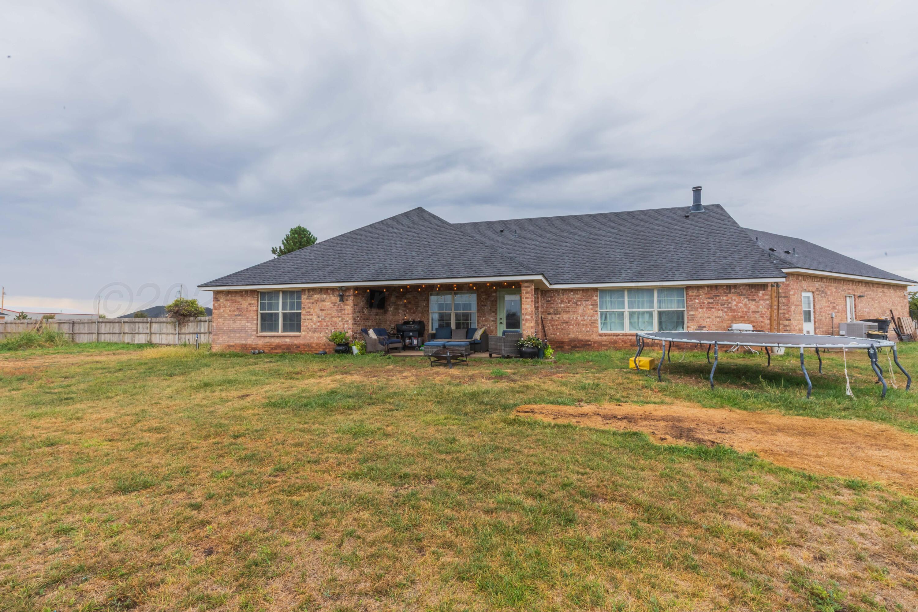 1301 Moon Ridge Lane Amarillo, TX 79124 - Photo 4 of 34 a front view of a house with a big yard and a large tree
