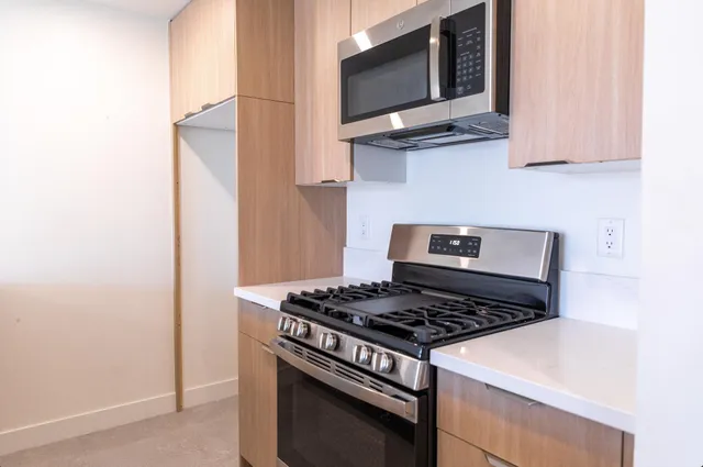 a kitchen with stainless steel appliances granite countertop a stove and a microwave