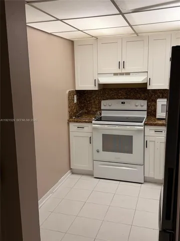 a stove top oven sitting inside of a kitchen