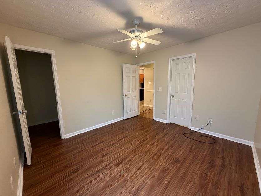 5196 Tew Lane Southwest Covington, GA 30014 - Photo 13 of 41 a view of an empty room with wooden floor and a ceiling fan