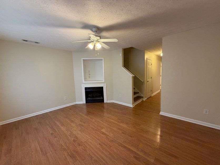 5196 Tew Lane Southwest Covington, GA 30014 - Photo 2 of 41 an empty room with wooden floor ceiling fan and windows