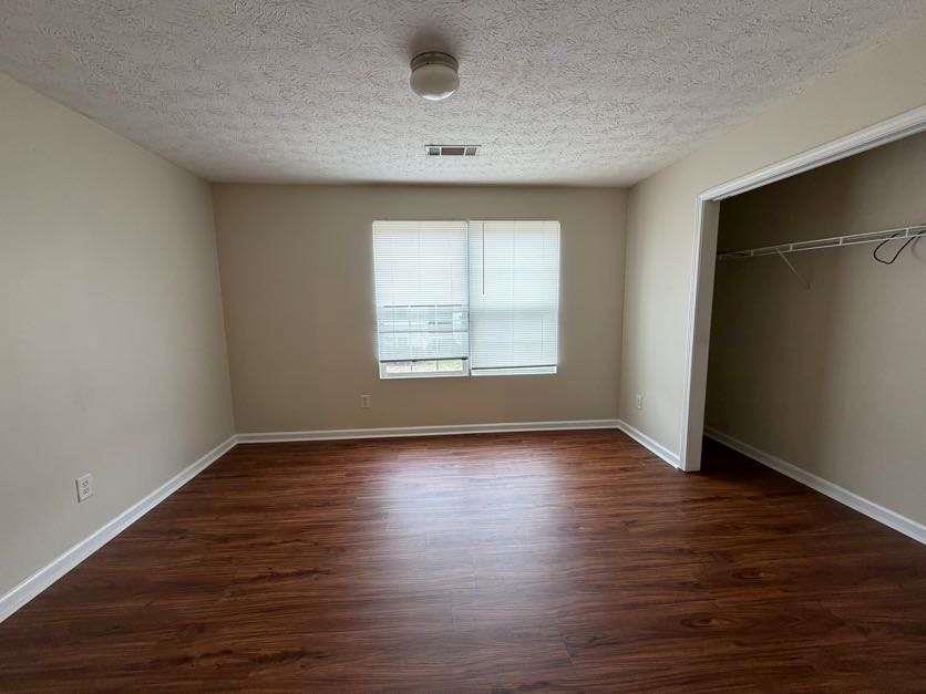 5196 Tew Lane Southwest Covington, GA 30014 - Photo 21 of 41 an empty room with wooden floor and windows