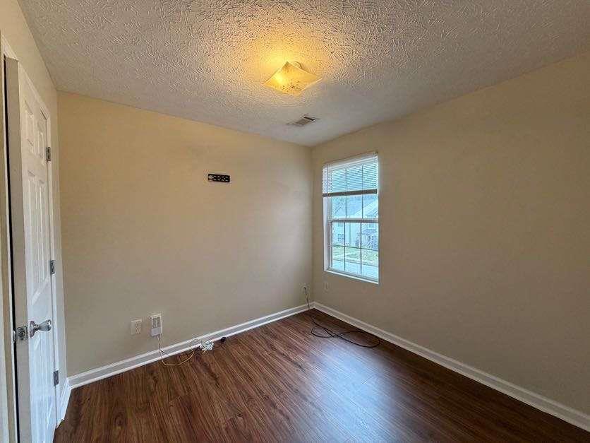 5196 Tew Lane Southwest Covington, GA 30014 - Photo 25 of 41 an empty room with wooden floor and windows