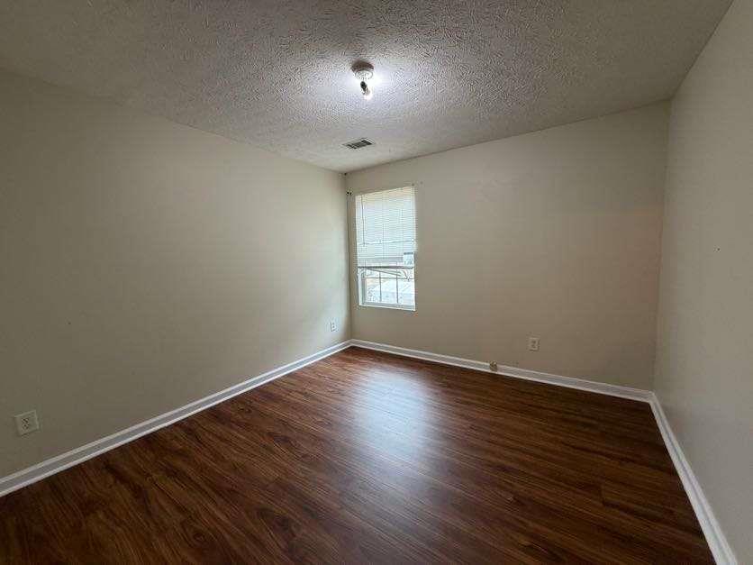 5196 Tew Lane Southwest Covington, GA 30014 - Photo 29 of 41 an empty room with wooden floor and windows