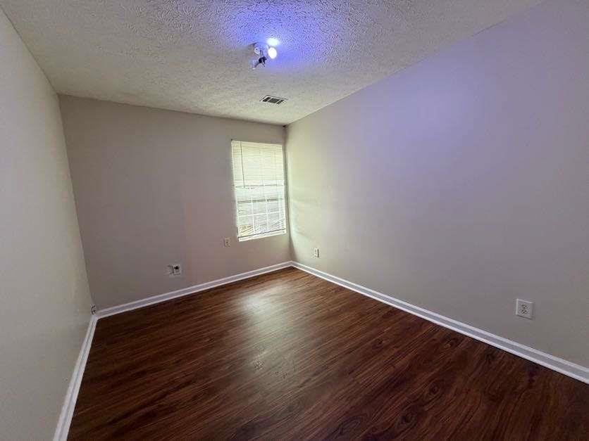 5196 Tew Lane Southwest Covington, GA 30014 - Photo 31 of 41 a view of an empty room with wooden floor and a window