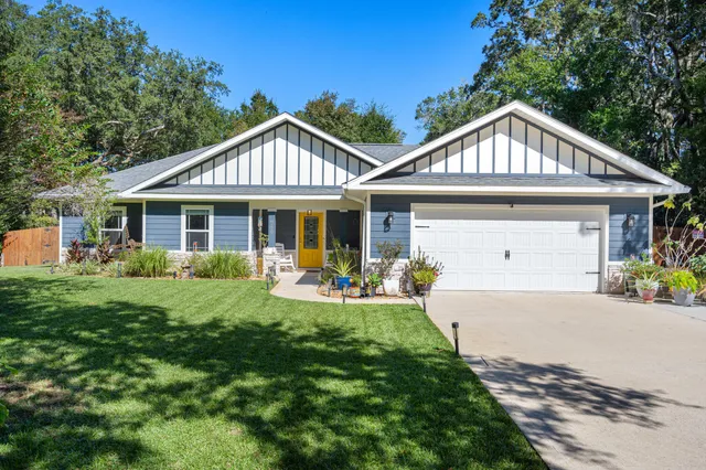 a front view of a house with yard and green space