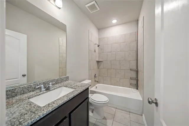 a bathroom with a granite countertop sink a toilet and shower