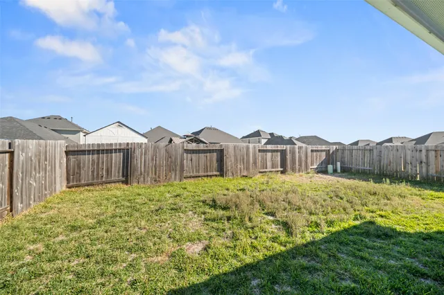 a view of a house with a yard and wooden fence