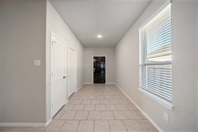 a view of a hallway with an empty room and a window