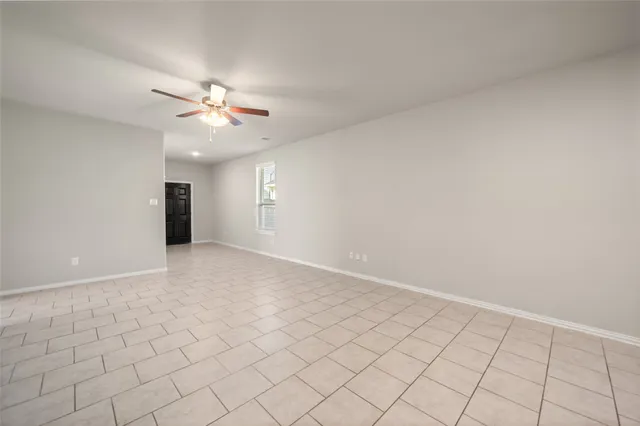 a view of an empty room and a ceiling fan window