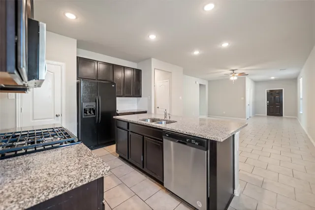 a kitchen with stainless steel appliances granite countertop a sink stove and refrigerator