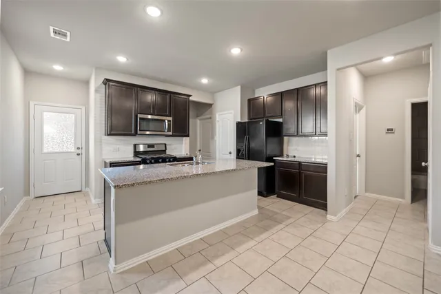 a kitchen with stainless steel appliances a refrigerator sink and microwave