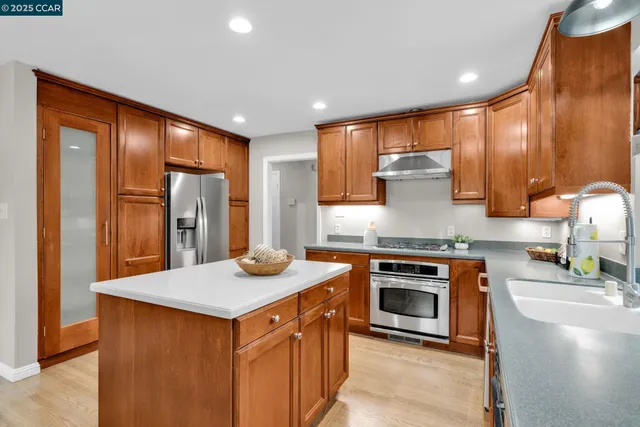 a kitchen with stainless steel appliances granite countertop a sink stove and refrigerator